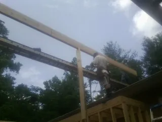Carpenter setting a ridge beam over a new addition frame — Ice Dam Removal by Roofing Brothers in Broad Run