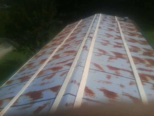 Rusted metal roof panels with new wood purlins before replacement — Storm Damage Roof Repair in Broad Run by Roofing Brothers
