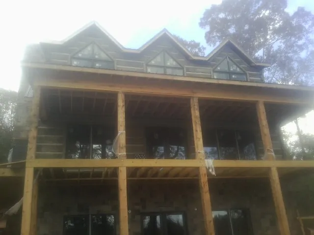 Dormers and porch framing on a large log home under construction — Roof Coating work by our crew in Broad Run