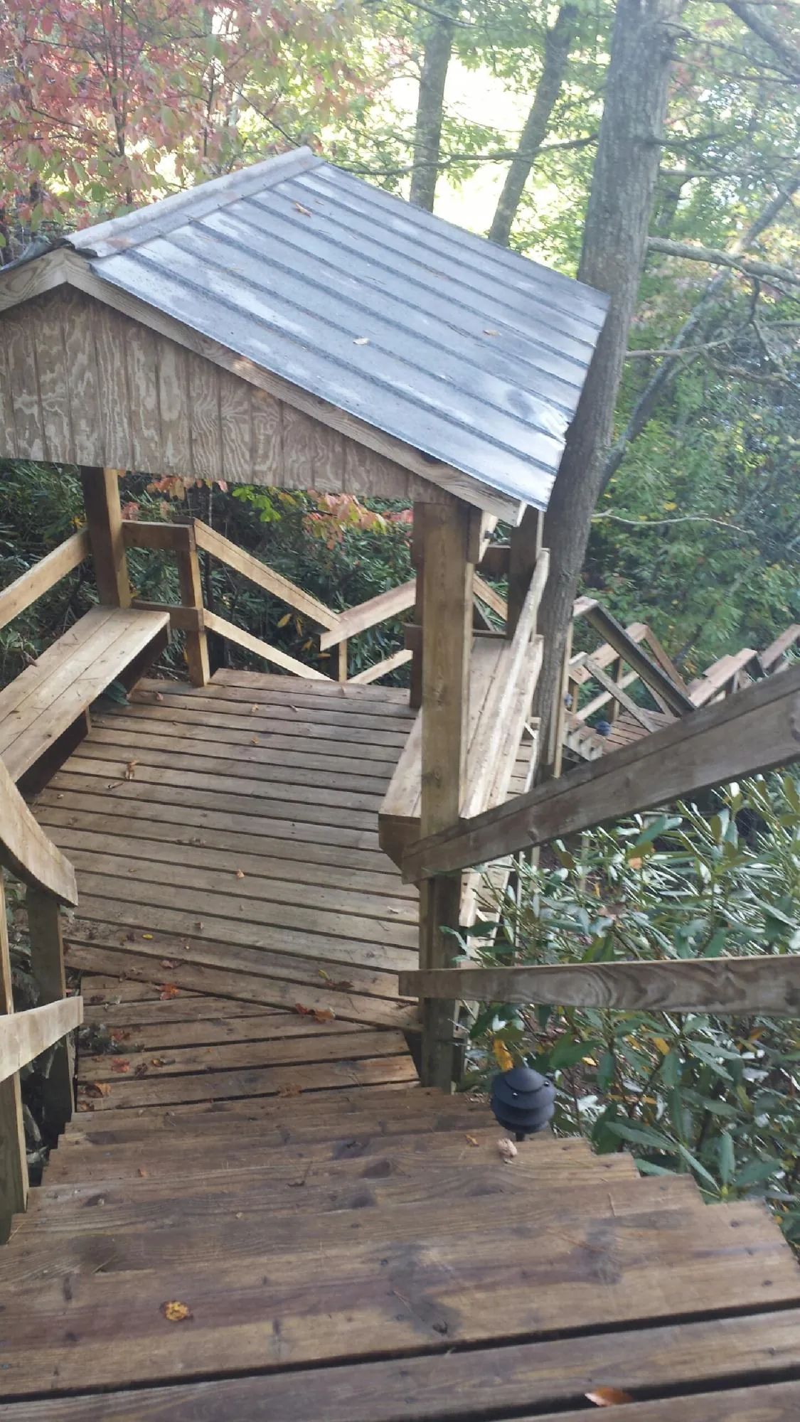 Metal roofed shelter over wooden steps on a wooded walkway — Skylight Repair & Installation work by our crew in Broad Run