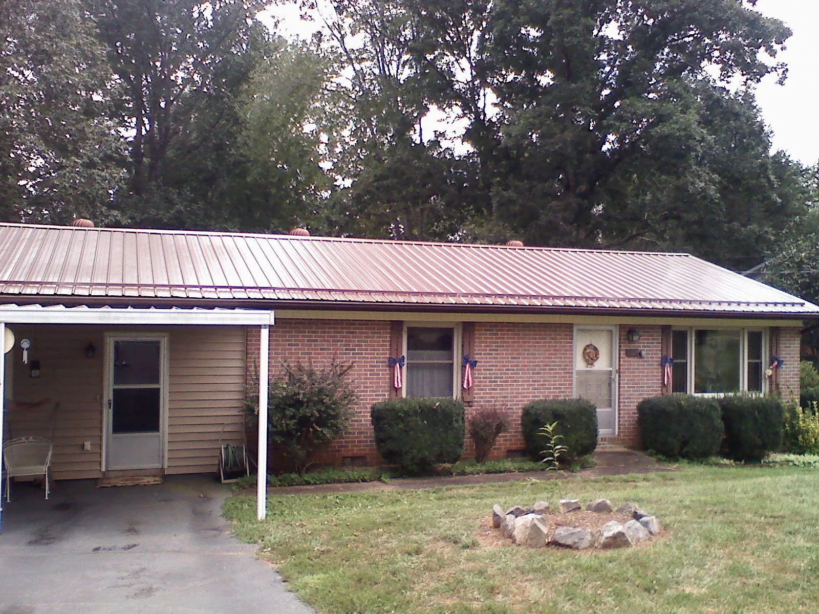 Bronze metal roof and carport on a brick ranch home — Roof Repair work by our crew in Broad Run